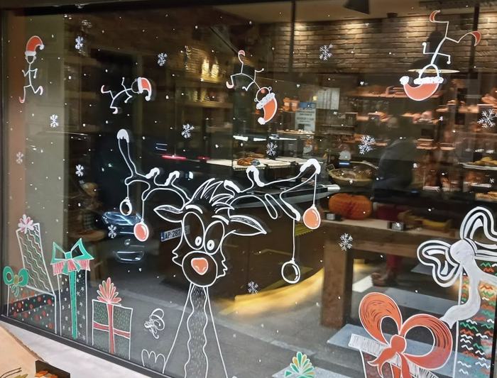 Vitrine de boulangerie avec renne et cadeaux de Noël